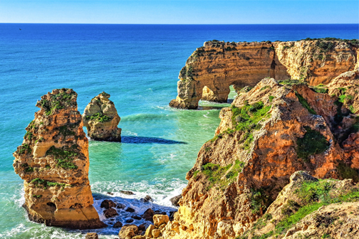 Praia da Marinha in de Algarve met goudkleurige rotskliffen, helder turquoise water en een zandstrand langs de ruige Portugese kust.